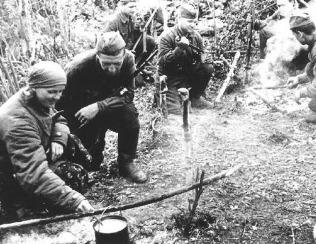Una guerrillera prepara una comida en el fuego para sus camaradas