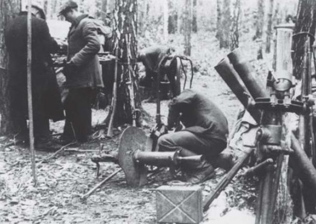 Partisano limpiando una ametralladora Schwarzlose 1907-1912 usada por las fuerzas de seguridad húngaras. Nótese el escudo de ametralladora Maxim que ha sido añadido. A la derecha de la imagen se pueden apreciar tubos de mortero y fusiles Mosin-Nagant posiblemente lanzados en paracaídas por la aviación del Ejército Rojo