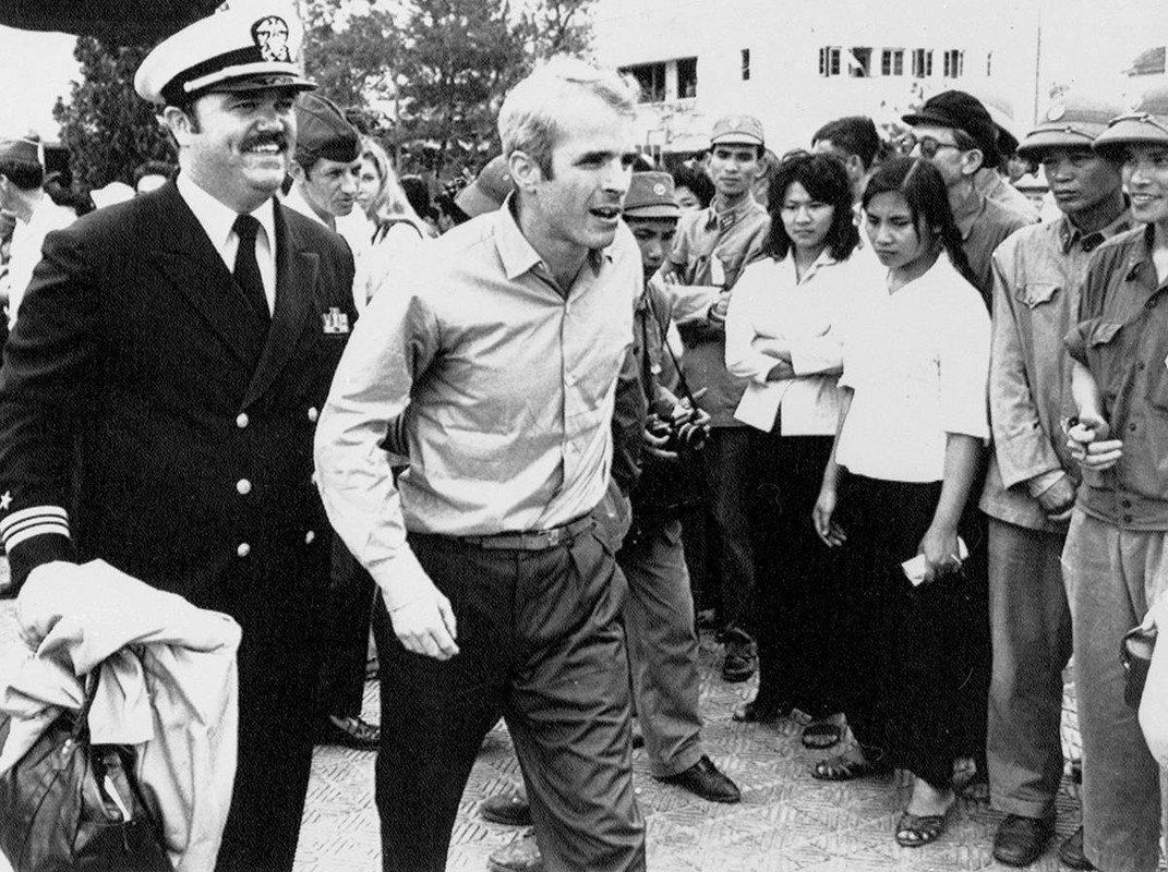 In this March 14, 1973, file photo, U.S. Navy Lt. Cmdr. John McCain, center, is escorted by Lt. Cmdr. Jay Coupe Jr., to Hanoi, Vietnam’s Gia Lam Airport, after McCain was released from captivity.